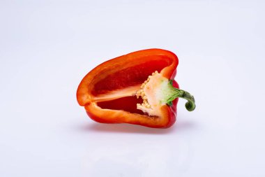 Kırmızı biber, beyaz arkaplan önünde yarı yarıya izole edilmiş.