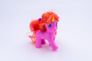 Beyaz arka planda izole edilmiş pembe tek boynuzlu at oyuncağı.