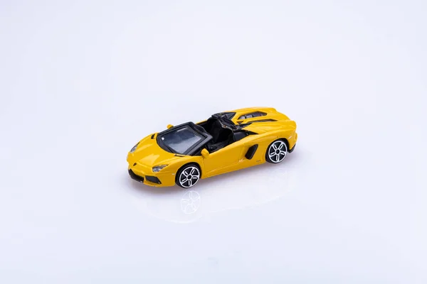 small yellow sport car toy isolated in front a white background