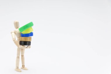 Beyaz arka planda plastik tıkaçlar taşıyan tahta kukla.