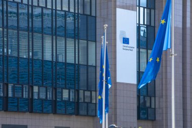 BRUSSELS, Belgium - fourth of may 2020 : European Council. European flags floating in front of the European Council, Brussels, Belgium clipart