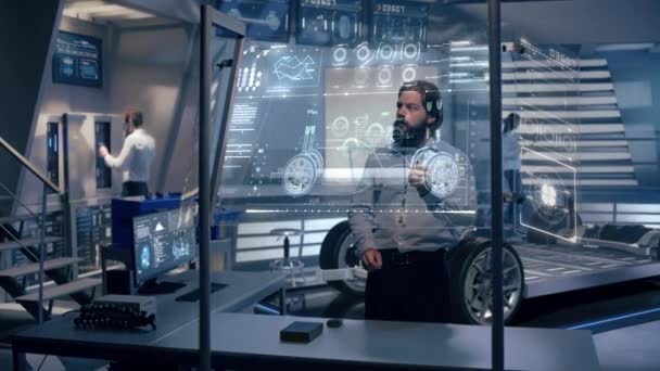 秘密研究室内のデジタルスクリーンで未来のホログラフィックカーを分析するエンジニア — ストック動画
