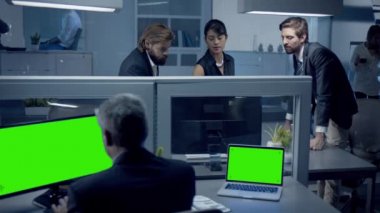Çeşitli profesyoneller gece geç saatlere kadar çalışıp bilgisayardan veri izliyorlar. Masasında oturan orta yaşlı çalışan, Masaüstü ve Dizüstü bilgisayarını iki yeşil maket ekranlı kullanıyor.