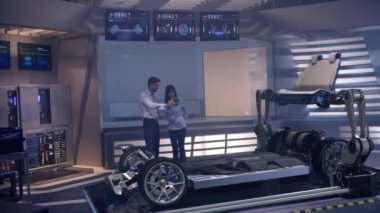 Otomotiv mühendisleri geliştirilmiş holografik teknoloji ve robotik kollar kullanarak elektrikli araba tasarımı üzerinde çalışıyorlar. Yüksek teknoloji endüstriyel tesis. Red Epic W Helyum 8k Sinema Kamerasında Çekim.