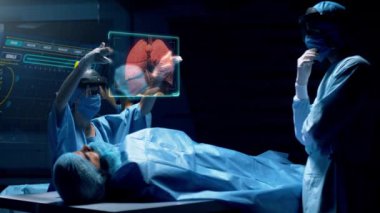 Artırılmış sanal gerçeklik holografik lens kulaklığı kullanan bir grup cerrah hasta organlarını gösteren sanal bir arayüzle etkileşim halindeler. Doktor akciğerleri analiz ediyor. Red Epic W Helyum 8k Sinema Kamerasında Çekim.
