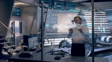 Otomotiv Mühendisleri Artırılmış Holografik Teknoloji ve Gelecek Ekranları kullanarak Elektrikli Araba Prototipinin Tasarım ve Performansını Analiz Ediyor. Yüksek teknolojili endüstriyel tesis. Red Epic W Helyum 'da çekilmiştir..