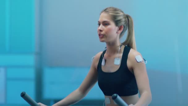 Science High Tech Sports Labでは 美しいアスリートウーマンが体に取り付けられた電極を使ってトレッドミルを歩きます 閉めろスローモーション Arri Alexa Mini — ストック動画