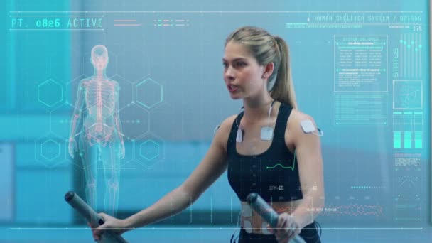 Science High Tech Sports Labでは 美しいアスリートウーマンが体に取り付けられた電極を使ってトレッドミルを歩きます Ecgとホログラフィックデータのオーバーレイ スローモーション Arri Alexa — ストック動画