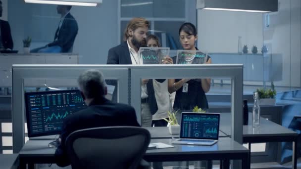 Équipe diversifiée de négociants, courtiers et investisseurs en valeurs mobilières Travailler tard dans la nuit Analyser les données sur les tablettes futuristes numériques, discuter de l'information sur les investissements à haut risque. Tourné sur Red Epic W Helium 8K .