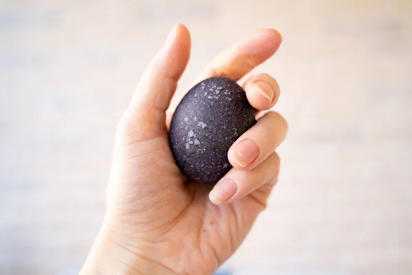 black egg in hand