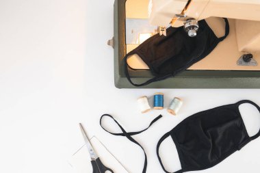 Dikiş makinesi olan ev işi, beyaz izole edilmiş arka planda koruyucu ilaç koronavirüs maskesi iplikleri.