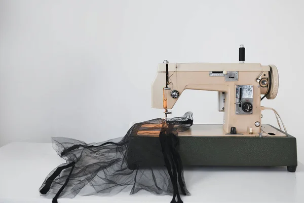 Processus de couture de fatin de maille sur la machine à coudre à la maison sur le lieu de travail sur un fond blanc — Photo