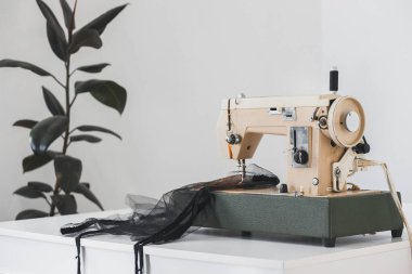 Evdeki dikiş makinesinin üzerine ağ yağı dikme işlemi beyaz arka planda işyerinde