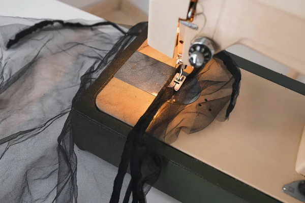 Processus de couture de fatin de maille sur la machine à coudre à la maison sur le lieu de travail sur un fond blanc — Photo