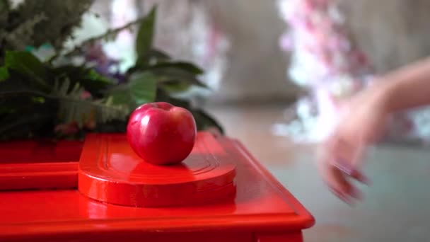 Κορίτσι Παίρνει Ένα Κόκκινο Μήλο Από Την Κόκκινη Επιφάνεια — Αρχείο Βίντεο