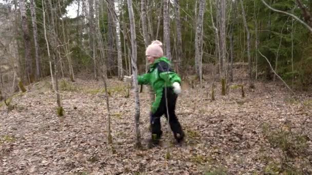 Блондинка в зеленому комбінезоні бігає і танцює в весняному лісі — стокове відео