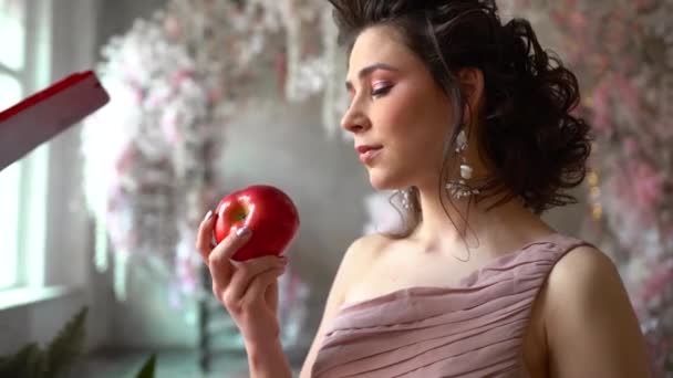 Una Hermosa Chica Mira Una Manzana Roja Quiere Morderla Comerla — Vídeos de Stock