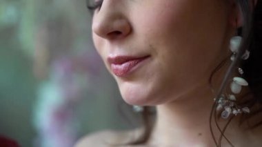 Kızın dudakları kırmızı bir elmayı ısırır ve yer. Kadının yüzü çok yakın, sadece ağzı görünüyor. Çenesi açılır ve yemek yer. Dişler meyveleri ısırır. Dudakları rujla boyanmış..