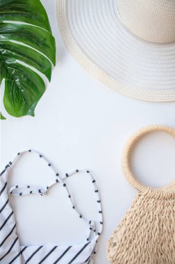 Yassı bikini, şapka, güneş gözlüğü, denizyıldızı, beyaz arka planda yeşil erik yaprağı. Yaz tatili kavramı. Tropik poster, kartpostal.