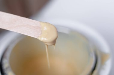 Beyaz arkaplandaki balmumu ve tahta çubuk tüy döküyor.