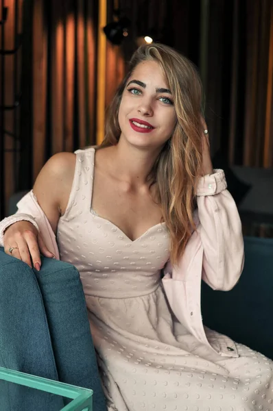 portrait of smiling pretty woman in pink dress in cafe drinking red tea with donuts and enjoy