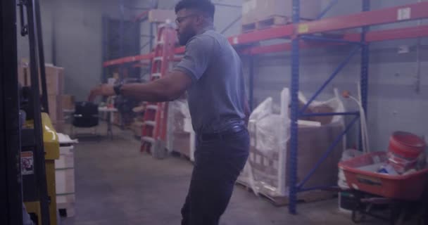 フォークリフトを使用して倉庫でアフリカ系アメリカ人マネージャー — ストック動画