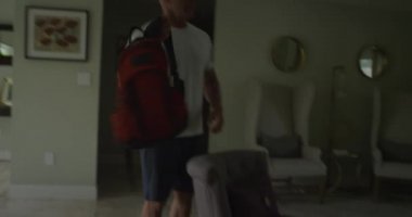 Spor elbiseli bir adam evden çıkıyor.