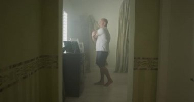 Adam uyanır ve yatak odasında gerinir.