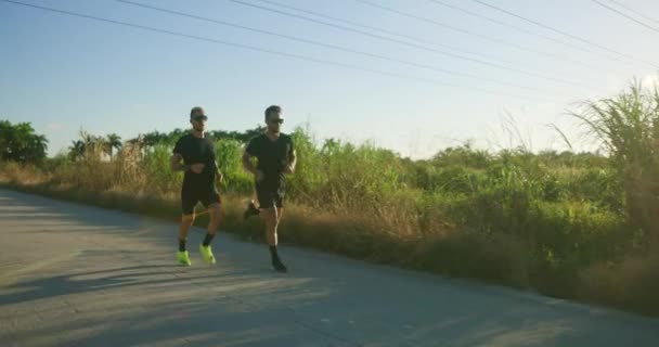 Due Atleti Maschi Gareggiano Strada Correndo Tramonto — Video Stock