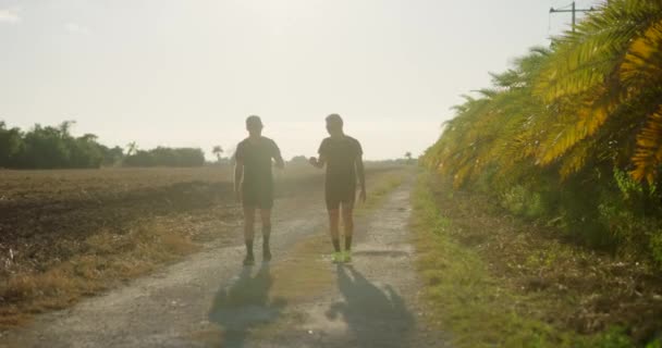 Dois Corredores Masculinos Recuperam Após Correr Pôr Sol — Vídeo de Stock
