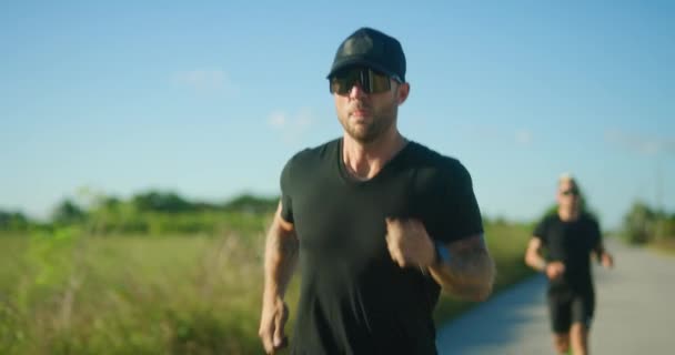 Dos Atletas Masculinos Compiten Carretera Corriendo Atardecer — Vídeo de stock