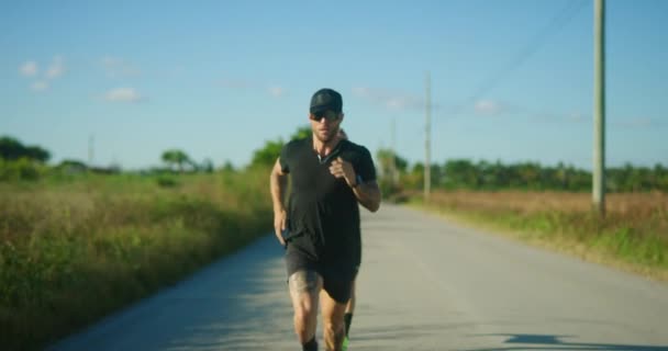 两名男子运动员在日落时分在公路上赛跑 — 图库视频影像