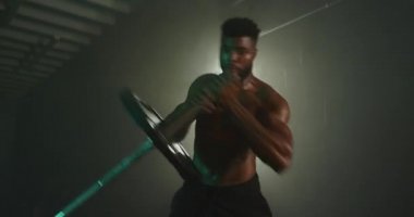 Adam karanlık spor salonunda çalışıyor.