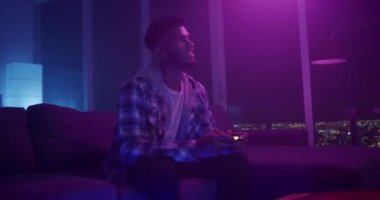 Geceleri evde video oyunu oynayan bir adam.