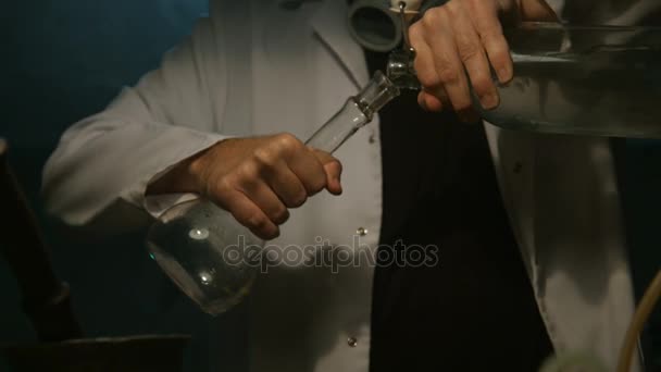 Cientista estranho derrama líquido em um frasco — Vídeo de Stock