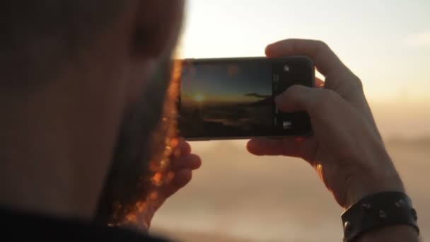 Jovem turista tirando fotos do pôr do sol — Vídeo de Stock