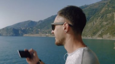 Mutlu adam üstünde hareket eden telefon fotoğraf yapıyor