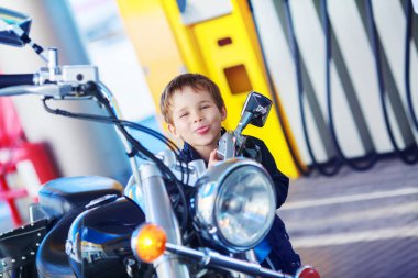 dilini out duran bir motosiklet yakınındaki asılı olan küçük çocuk