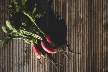Bahçeden toplanmış taze turplar, ahşap bir masada oturuyorlar.