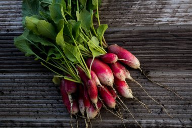 Bahçeden toplanmış taze turplar, ahşap bir masada oturuyorlar.