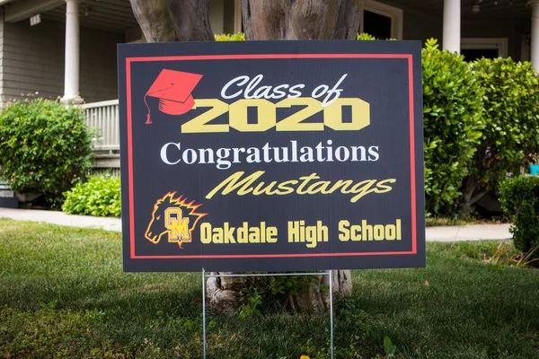 OAKDALE, CALIFORNIA / ABD - 29 Nisan 2020: Cemaatteki insanlar covid salgını sırasında 2020 mezunlarını tebrik etmek için ön bahçelerine tabelalar astılar.