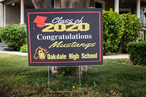 OAKDALE, CALIFORNIA / ABD - 29 Nisan 2020: Cemaatteki insanlar covid salgını sırasında 2020 mezunlarını tebrik etmek için ön bahçelerine tabelalar astılar.