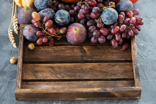 Uve, fichi e prugne in una scatola di legno, raccolta biologica autunnale , — Foto Stock