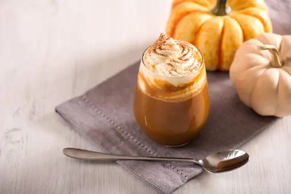 Pumpkin spice latte, hot coffee drink with pumpkins, whipped cre