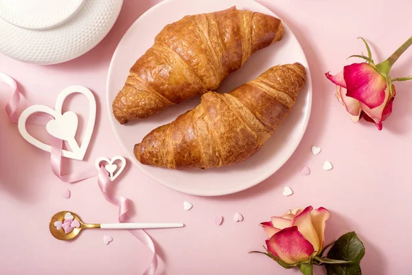 Café da manhã romântico com croissants, rosas em fundo rosa, Va — Fotografia de Stock