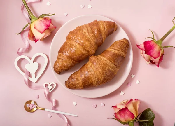 Café da manhã romântico com croissants, rosas em fundo rosa, Va — Fotografia de Stock