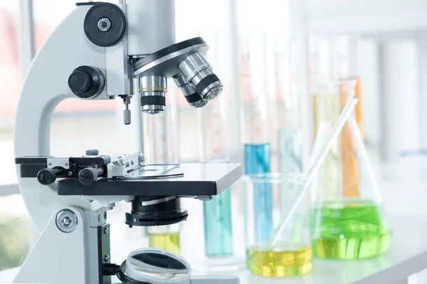 Laboratuvarda, biyoteknoloji araştırmalarında ve covid-19 ve corona virüsünün tıbbi tedavisinde pek çok test tüpü ve büyük deney tüpleri bulunan mikroskop..