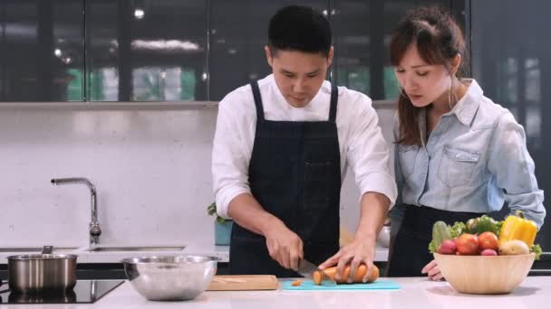 Чоловічий Шеф Кухар Навчає Молоду Жінку Практикувати Різання Моркви Кухні — стокове відео