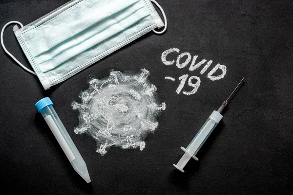 Copyspace on a chalk board. Medical mask, gloves, syringe and test tube