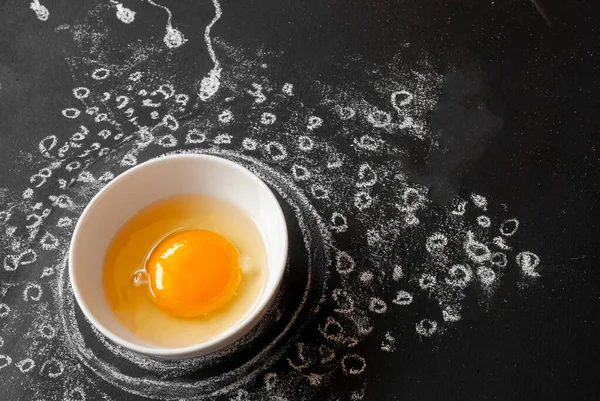 Tüp bebek konsepti. Tebeşirle çizilmiş siyah tebeşir tahtasında yumurta ve sperm. Yumurta, beyaz kasedeki tavuk yumurtasıdır. Döllenme sürecinin gösterimi